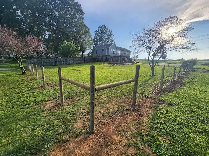 Fence line and field opening where a driveway gate and conduit run would go